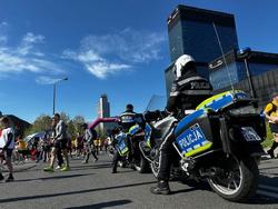 zdjęcie kolorowe: policjant na motorze nadzorujący bezpieczeństwo biegu