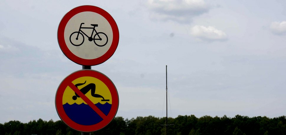 Dwa znaki: zakazu kąpieli i zakazu ruchu rowerom.