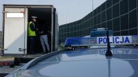 Obrazek przedstawi policjanta oraz kierowcę samochodu ciężarowego, który pokazuje mu że w prawidłowy sposób ma zabezpieczony ładunek