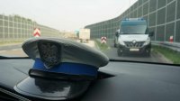 Obrazek pokazuje czapkę policjanta w tle pojazd ITD