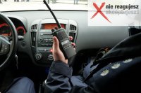 Obrazek przedstawia ramię umundurowanego policjanta w radiowozie, który trzyma w ręku radiostację, w prawym górnym rogu napis: nie reagujesz-akceptujesz