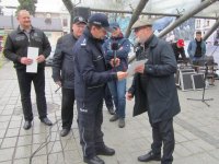 Obrazek przedstawia  Komendanta Miejskiego Policji w Tychach insp. Andrzeja Trzcińskiego składającego podziękowania Burmistrzowi Miasta Ustroń, na scenie widoczne inne osoby