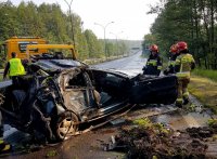 Obrazek przedstawia strażaków przy samochodzie z wypadku oraz lawetę