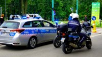 Obrazek przedstawia policjantów na policyjnych motocyklach po prawej stronie, a po lewej radiowozy