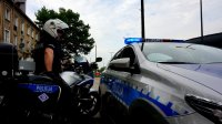Obrazek przedstawia policjanta na motorze oraz radiowóz oznakowany