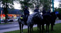 Obrazek przedstawia czterech policjantów na koniach, w tle stadion miejski