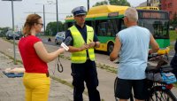 Na zdjęciu widoczna symulacja wypadku drogowego-potrącenie rowerzysty przez autobus oraz rozmawiającego z rowerzystą policjanta ruchu drogowego obok nich stoi kobieta trzymając mikrofon &quot;Radia Expres&quot;
