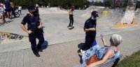 Policjanci podczas spotkania profilaktycznego rozmawiają z kobietą w skateparku.