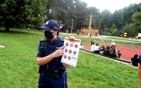 Policjantka pokazuje dzieciom kartę ze znakami dot. bezpiecznej kąpieli.