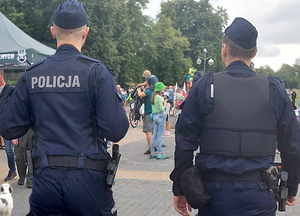 Widoczne plecy policjantów i dalej uczestnicy obchodów Święta Wojska Polskiego.