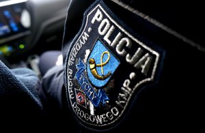 Na zdjęciu rękaw policyjnej kurtki z naszywką. Na naszywce widocznym napis o treści: Komenda Miejska Policji w Tychach, Wydział Ruchu Drogowego.