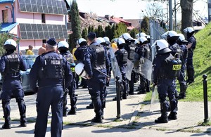 Na zdjęciu umundurowani policjanci oddziałów prewencji zabezpieczający przejście kibiców.