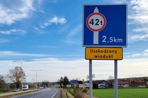Na zdjęciu droga oraz znak ostrzegawczy informujący o zakazie ruchu pojazdów o masie przekraczającej 42 tony. Poniżej znaku tabliczka z napisem uszkodzony wiadukt. Fotografia Urząd Miasta Tychy.