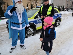 Na zdjęciu umundurowany policjant oraz Mikołaj podczas rozdawania odblasków.