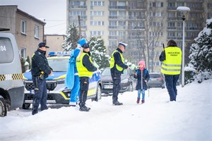 Na zdjęciu policjanci, strażnicy miejscy oraz Mikołaj rozdający odblaski.