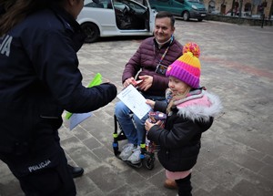 Na zdjęciu policjantka oraz dziecko z opiekunem podczas obchodów 32. Finału Wielkiej Orkiestry Świątecznej Pomocy.