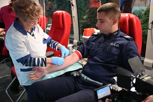 Na zdjęciu umundurowany policjant podczas oddawania krwi.