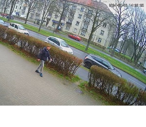 Na zdjęciu mężczyzna idący chodnikiem, którego wizerunek został opisany w komunikacie.