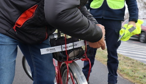 Na zdjęciu mężczyzna zakładający odblask na rower.